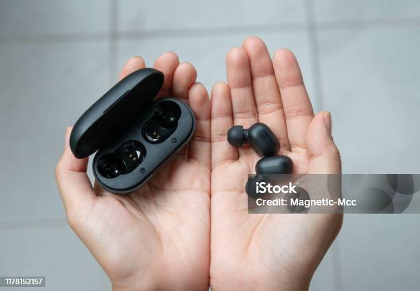 Close Up Of Woman Is Holding The Black True Wireless Earbuds Case In Hand Stock Photo - Download Image Now
