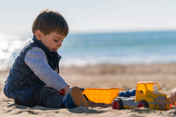 istock Boy playing with toy truck on the beach 1178152415