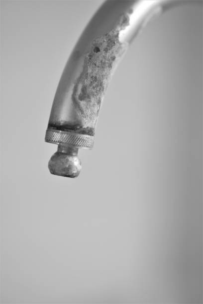 Old vintage metallic tap/faucet on an old shower with white tiled background giving space for copy