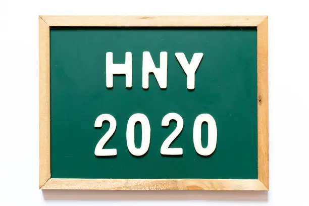Photo of Green blackboard and wood frame with word HNY (Happy New Year) 2020 on white background