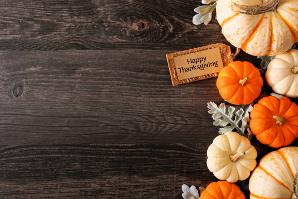 happy thanksgiving tag mit herbst seite rand von kürbissen und blätter auf einem dunklen holz hintergrund - miniature pumpkin stock-fotos und bilder