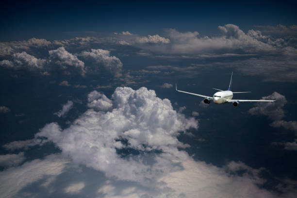 Night flight of a passenger jet airplane over clouds.