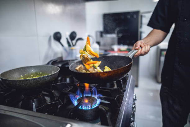 Pro cook making dinner Chef preparing a healthy dish burner stove top photos stock pictures, royalty-free photos & images