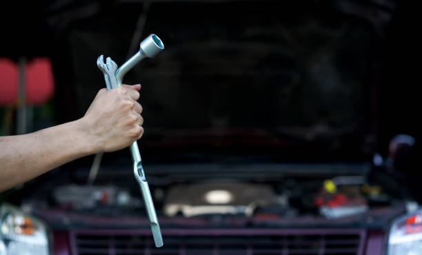 istock close up technician man hand holding two wrenches  over car's engine machinery background at garage repair shop for try to fixing problems , professional job concept 1178157032