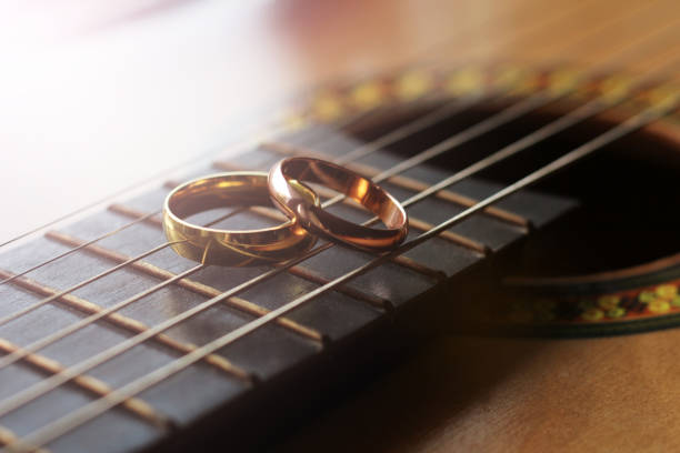 two gold wedding rings lie on guitar strings close-up, love and happy