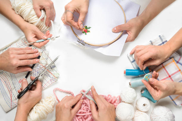 sewing flat lay composition with threads, fabrics, scissors, buttons and sewing accessories on a white background, women's hands do creative work knit sew embroider, - embroider imagens e fotografias de stock