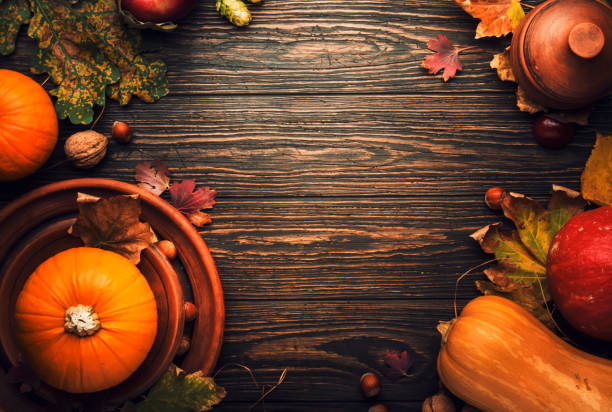 istock Thanksgiving dinner place setting. Autumn fruit, pumpkins, nuts, fallen leaves with plate and cutlery. Thanksgiving autumn background 1178164500
