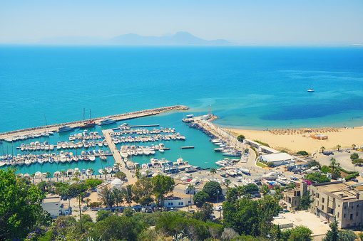 Sea, port with yachts and road along the coast-top view in Sidi Bou Said, Mediterranean marine landscape, Tunisia. June, 2019