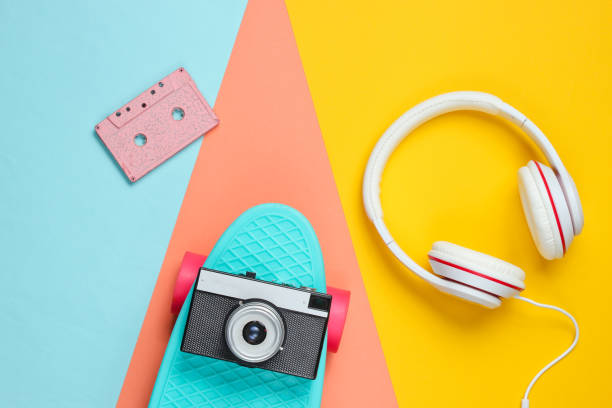 istock Hipster outfit. Skateboard with headphones, audio cassette on colored background. Creative fashion minimalism. Trendy retro 80s style. Minimal summer fun. Music concept. Top view 1178170069
