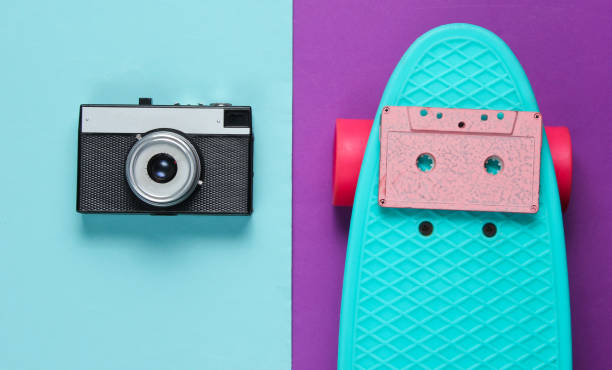 istock Retro set with blue skateboard with audio cassette and retro camera on colored background. Studio shot. Youth lifestyle. Top view 1178170103