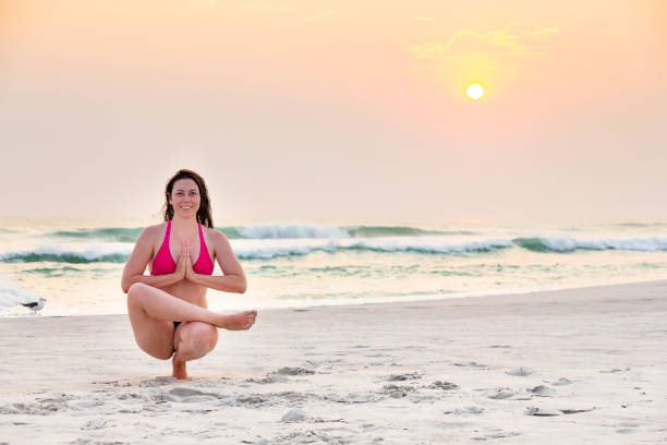 istock Woman practicing yoga on the beach during sunset 1178171122