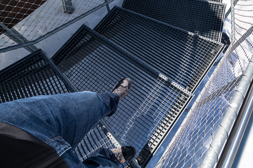 Person walking down a spiral staircase from an Egoperspective