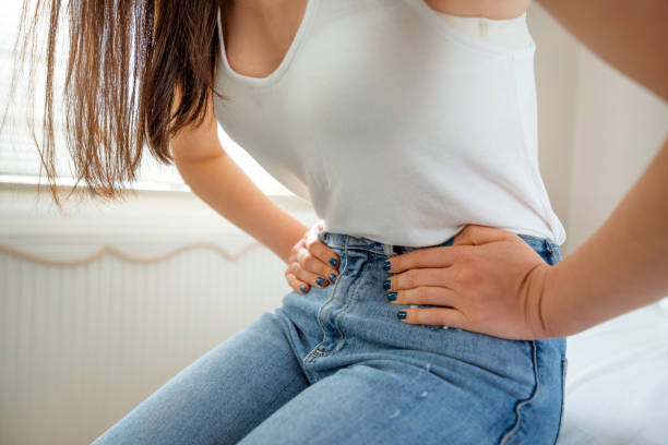 women issues, menstrual pain - torso women jeans abdomen imagens e fotografias de stock