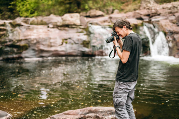 istock Male hiker photographing a waterfall in forest 1178175484