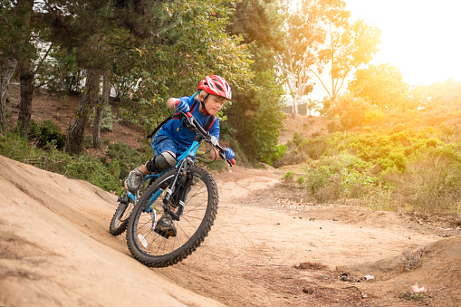 Speedy 7 Year Old Riding A Mountain Bike speeding through a forest.  Motion blur captures the essence of speed.