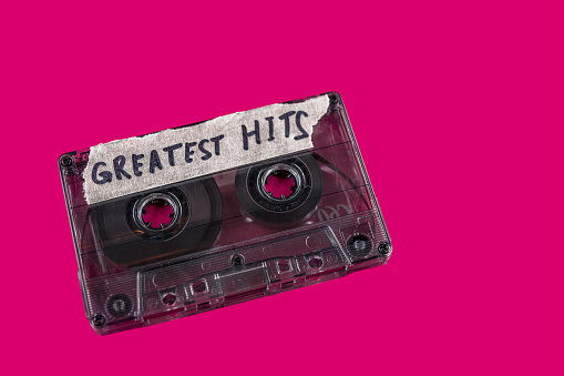 vintage old film music cassette on a red background with the inscription greatest hits, background music, music lovers