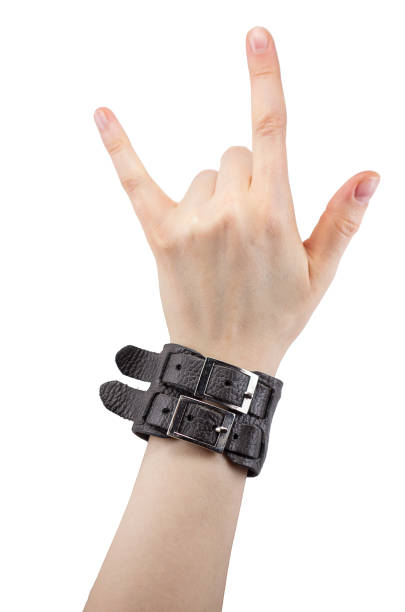 hand with leather rocker bracelet hand with leather rocker bracelet with rock and roll sign, rock music isolated on white background rocker nails stock pictures, royalty-free photos & images