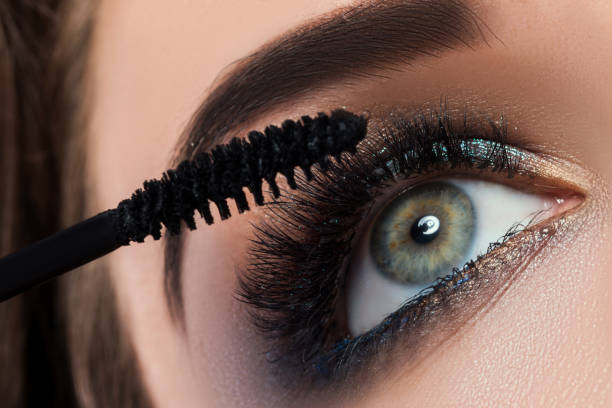 Close up of female eye with beautiful long lashes Close up of female eye with beautiful long lashes and mascara brush mascara wands stock pictures, royalty-free photos & images
