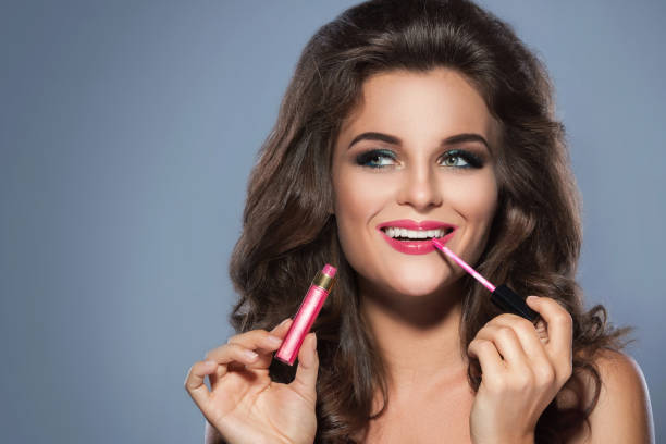 istock Beautiful woman applying lip-gloss 1178183455
