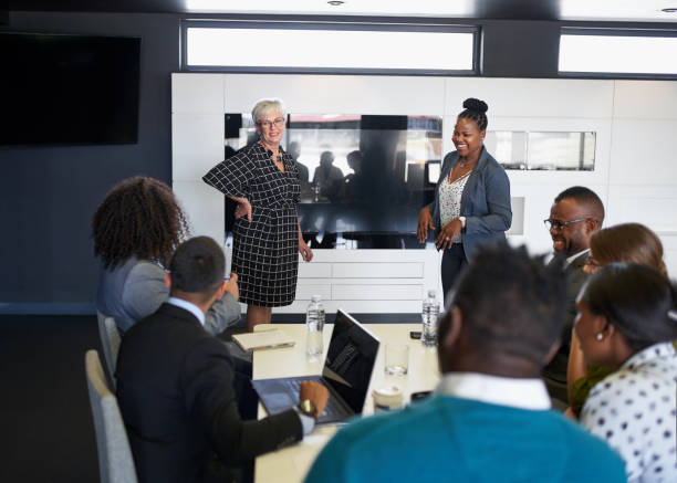 female-driven discussion between diverse multi-ethnic group of colleagues in modern meeting room - minority professional occupation business ethnic imagens e fotografias de stock