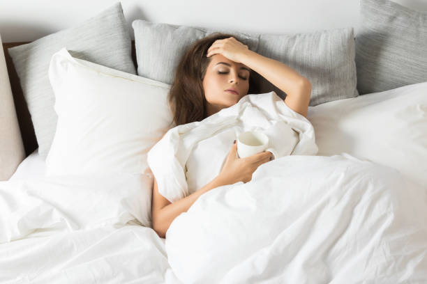 istock Sick woman sitting under a blanket 1178186259