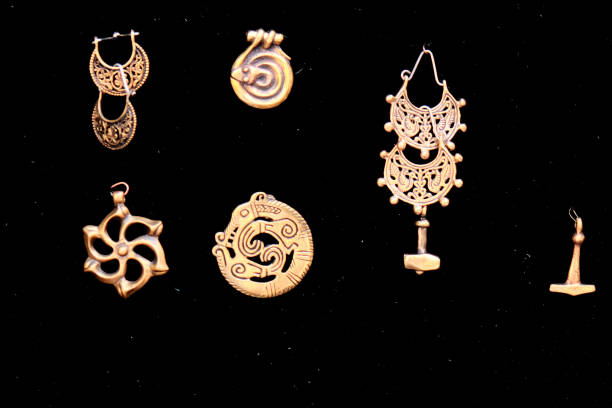 amuletos retro de metal amarillo, primer plano. colgantes de bronce con runas y animales sobre fondo negro. - ornamented accessory fotografías e imágenes de stock