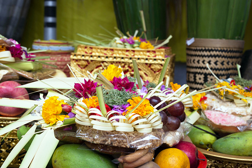 Traditional offerings to gods in Indonesia with flowers, fruits and aromatic sticks in temple, buddhist Bali