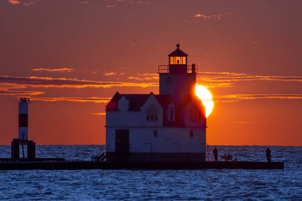 istock Lighthouse silhouetted in the warm light of huge summer sunrise. 1178199094