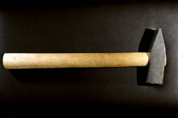 istock Close up of a heavy hammer in top view image, lying on leather surface. 1178200899