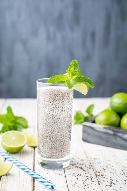 Mexican Energizing drink, Chia Fresca made from water, seeds, lime and sweetened with honey on rustic white wooden background with copy space