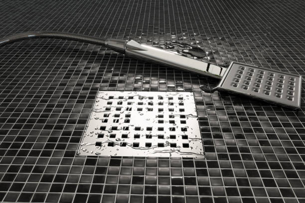 3d rendering of water drops on chrome metal gutter next to the laying shower head stock photo