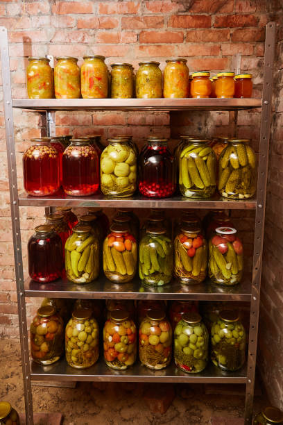 istock shelves with homemade pickled vegetables and stewed fruit. Vertical shot. 1178204208
