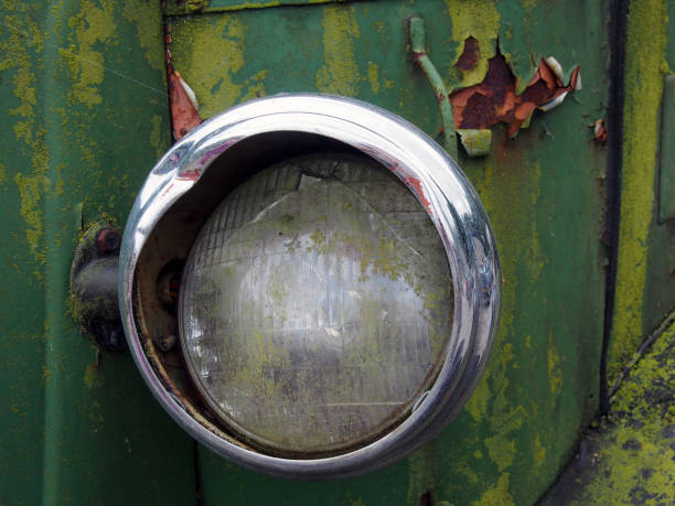 nahaufnahme des kaputten scheinwerfers eines alten verlassenen lkw mit verrosteter grüner lackierung - close up truck pick up truck gear stock-fotos und bilder