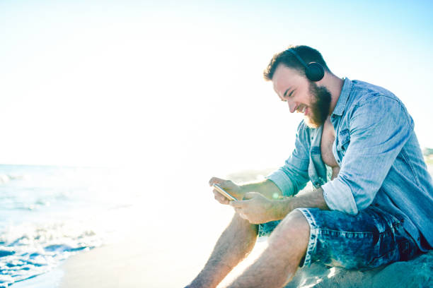 istock Male Enjoying Video Conference While Relaxing At The Beach 1178207019