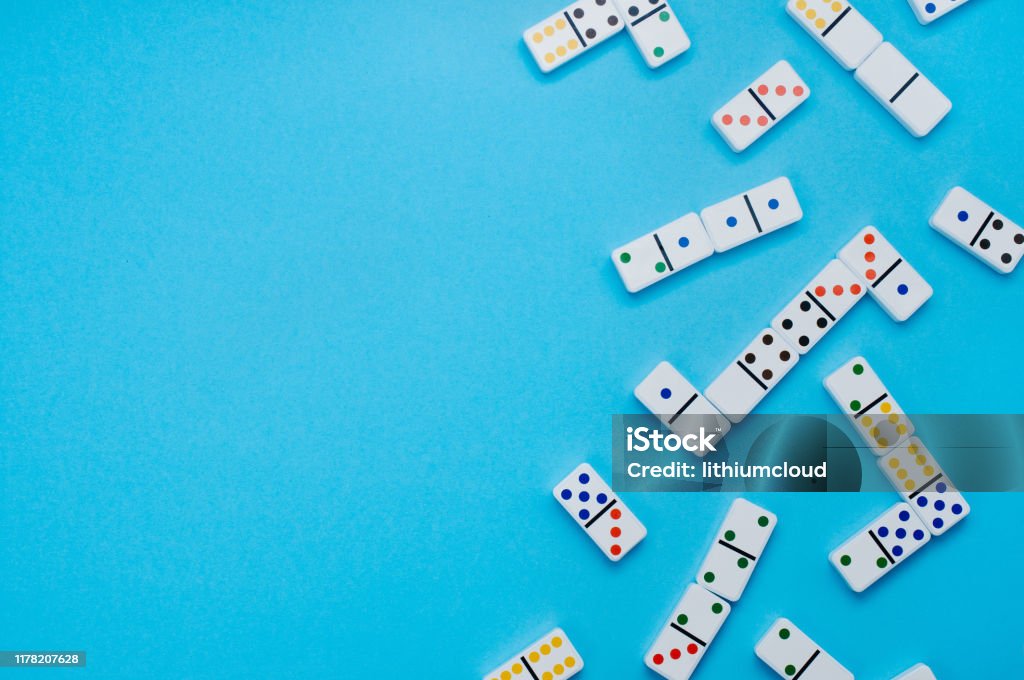 Dominoes on blue background with copy space Dominoes on blue background with blank space for text. Top view, flat lay. Domino Stock Photo