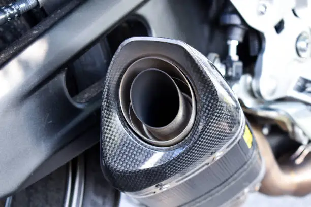 Photo of Close up view of a black carbon motorcycle exhaust pipe