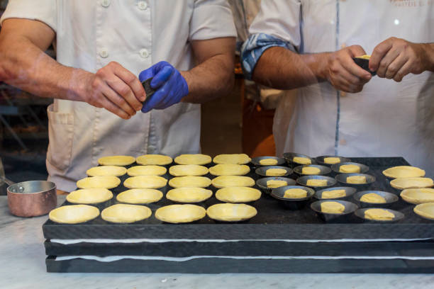 Confectioners making dough for the famous Portuguese cake "Pastel de Nata" Confectioners making dough for the famous Portuguese egg tart "Pastel de Nata" pasteis de belem stock pictures, royalty-free photos & images