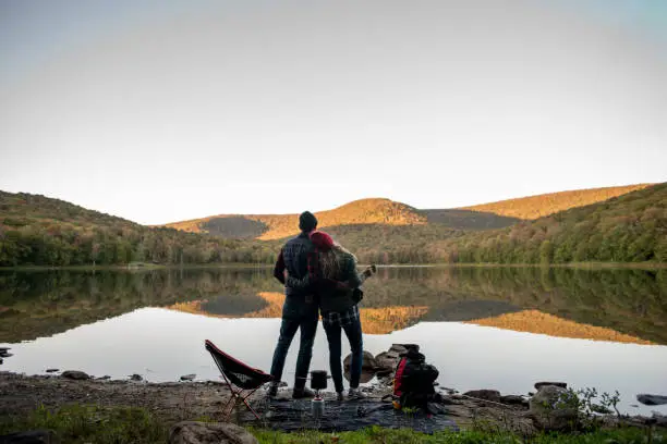 Photo of Couple relaxing near a lake while camping