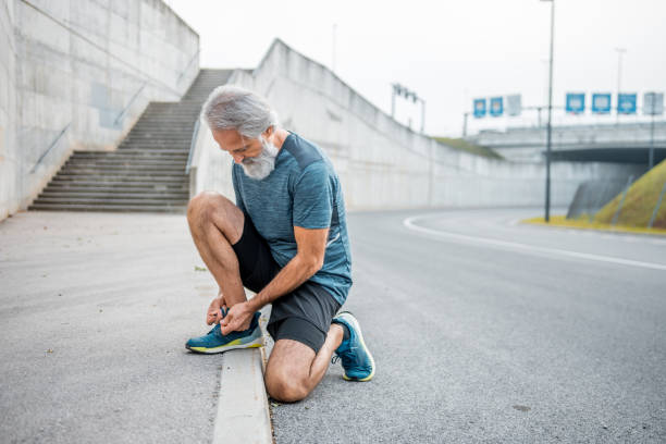istock Senior man tying his shoelaces before running 1178230252