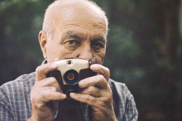 grandpa explaining grandson how to use retro camera