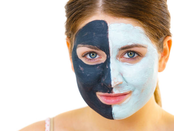 istock Girl with black white mud mask on face 1178240162