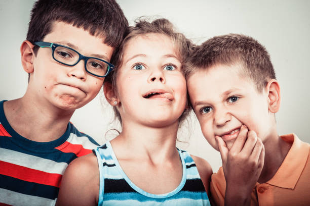 Crazy kids little girl and boys making silly face expression. Childhood fun.