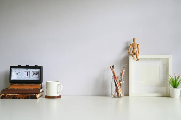 istock Workspace photo frame, coffee, alarm, books with plant decorate on white table. 1178248913