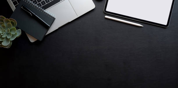 istock Top view of dark workplace with copy space, blank screen tablet and laptop computer 1178252883