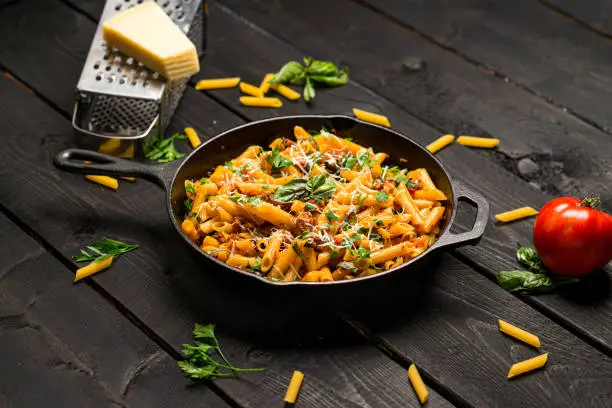 Penne one pot pasta dinner. This quick & delicious pasta meal is made with penne pasta, fresh tomato sauce and sausage. This italian inspired comfort food is cooked and served in a cast iron skillet.