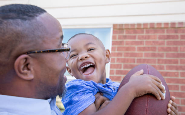 istock Son and dad playing football outside 1178254832