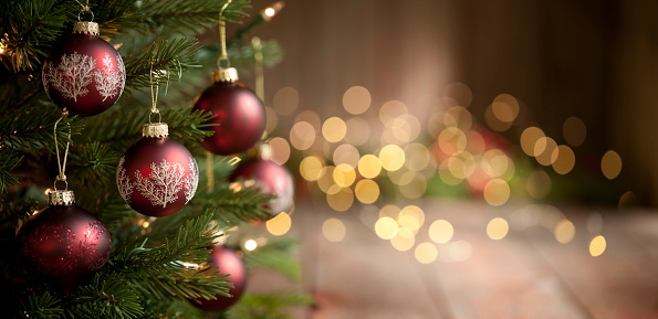 Christmas tree with baubles and lights against an old wood background