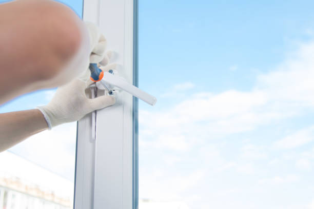 istock a worker in gloves, screwdriver screws the handle to a plastic window, against the sky, there is a place for inscription 1178262108