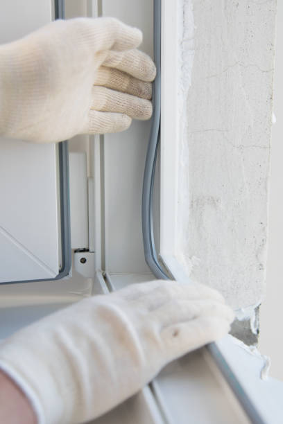 istock hands of the master in a protective glove, inserts into the frame of a plastic window, an elastic band for sealing, close-up 1178262127