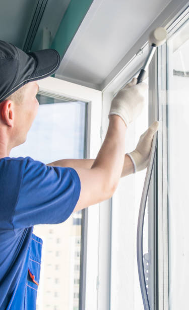 istock a worker in a blue uniform installs a double-glazed window in a plastic window frame, fixing it with a rubber mallet 1178262130